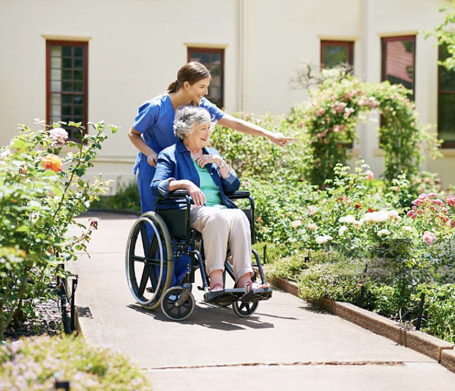 Senior couple walking their small white dog outside on a sidewalk surrounded by a beautiful green landscape